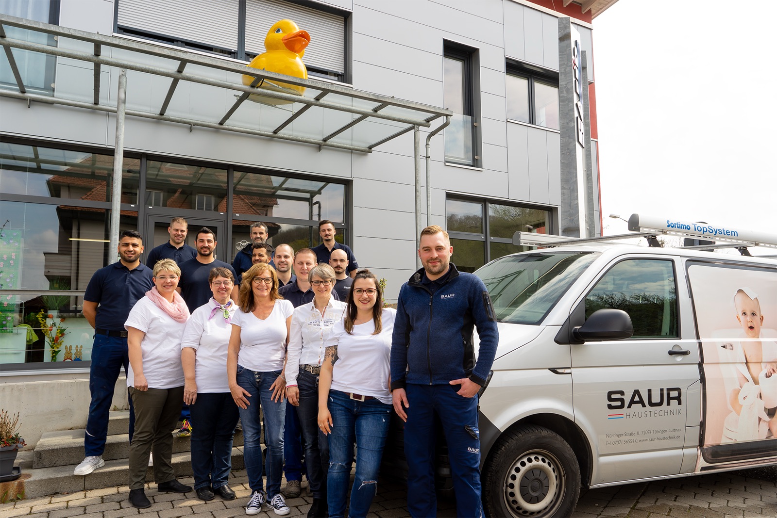 Das Kundendienst-Team von Saur Haustechnik mit Servicefahrzeug vor dem Firmengebäude